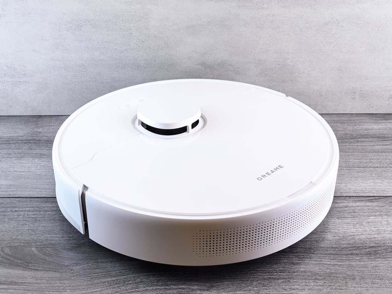 home-hero Sleek white robot vacuum cleaner on a wooden floor, perfect for smart home setups.